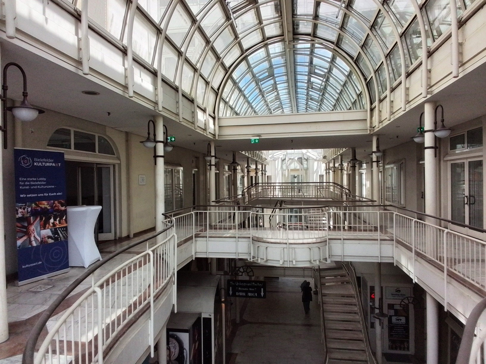 Die Architektur einer Einkaufspassage mit Marmor, Glas und Geländern.